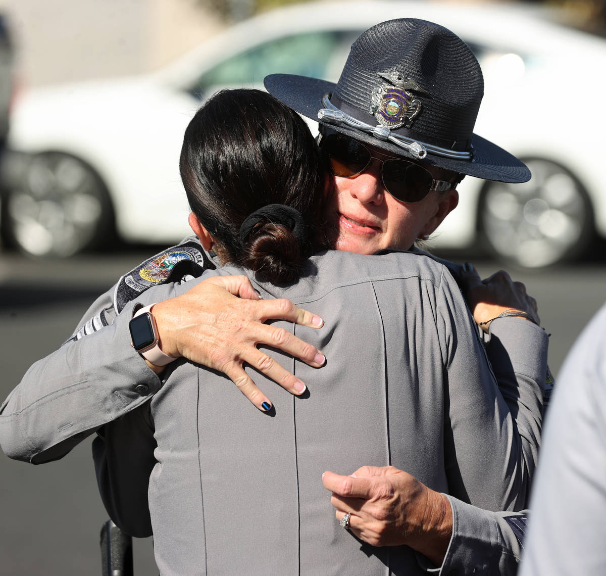 Nevada Highway Patrol Sgt. D. VanEllen, facing, who was trooper Micah May's sergeant, hugs Col ...