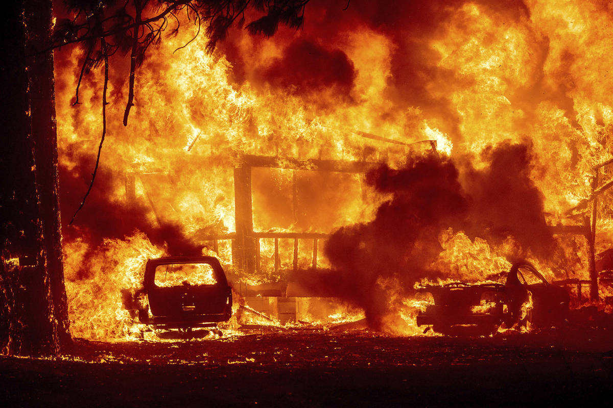 Flames consume a home on Highway 89 as the Dixie Fire tears through the Greenville community of ...