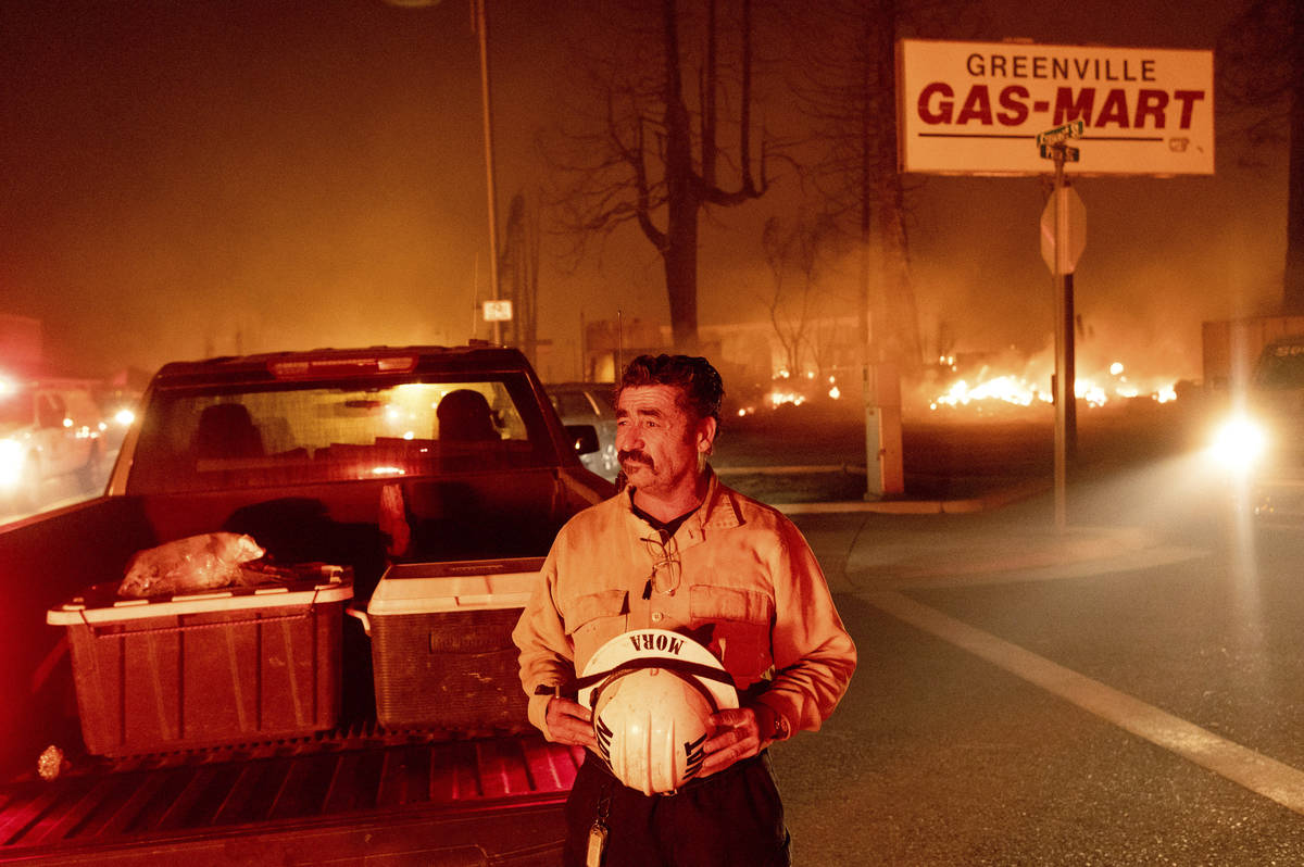 Battalion Chief Sergio Mora watches as the Dixie Fire tears through the Greenville community of ...