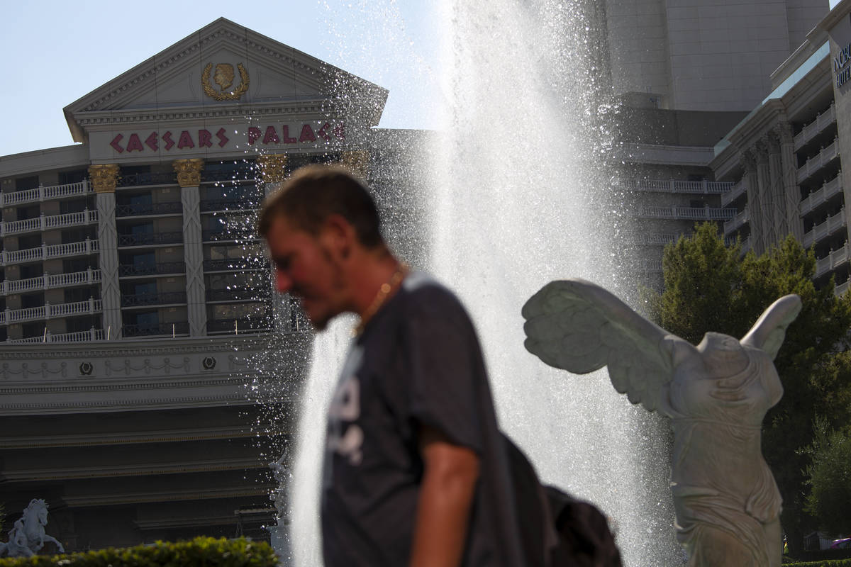 Pedestrians travel past Caesars Palace on Wednesday, Aug. 4, 2021, on the Las Vegas Strip. (Ell ...