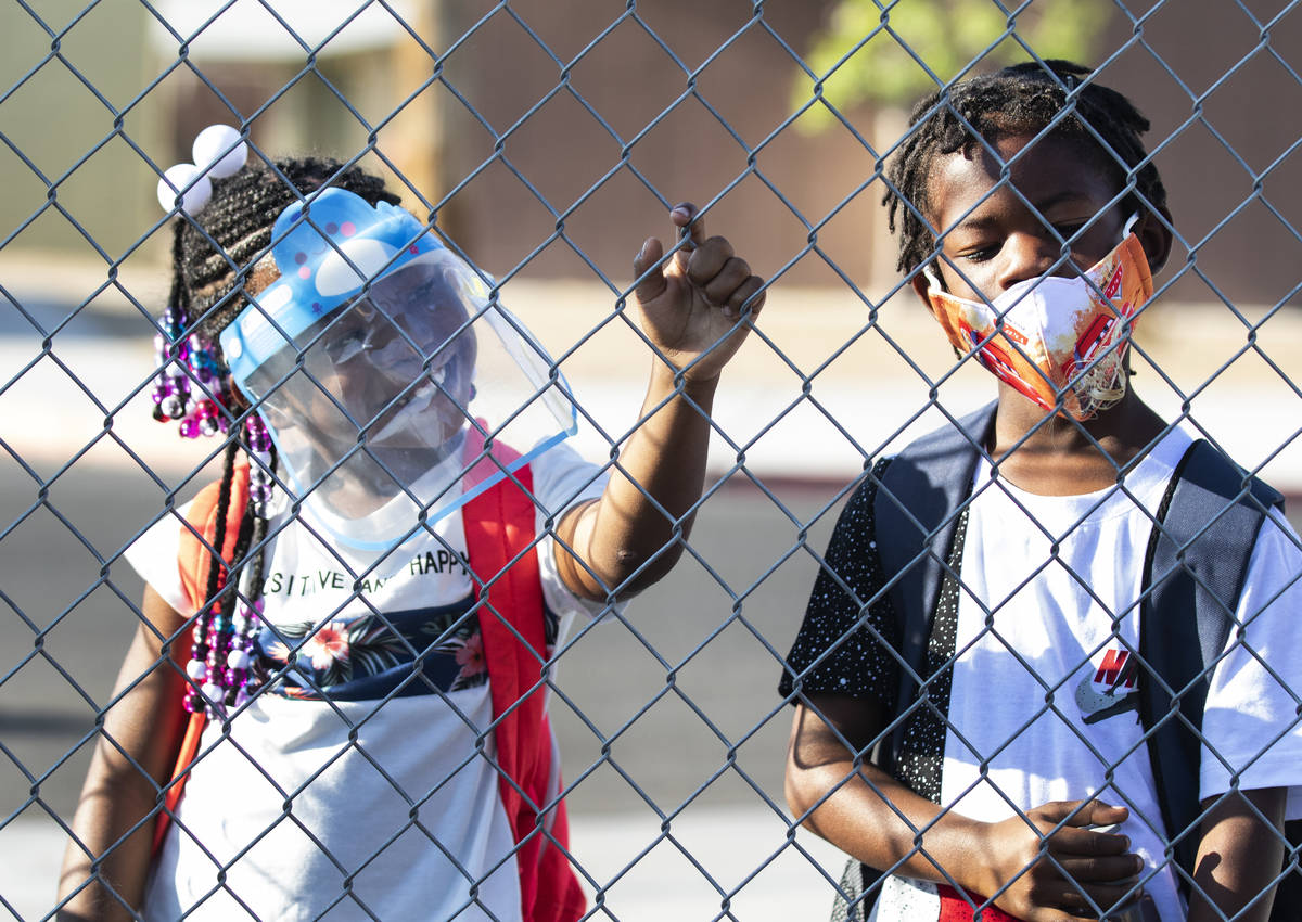 Kelly Elementary Community School students Kayla Shelby, 6, and her twin brother Kayleb wait in ...