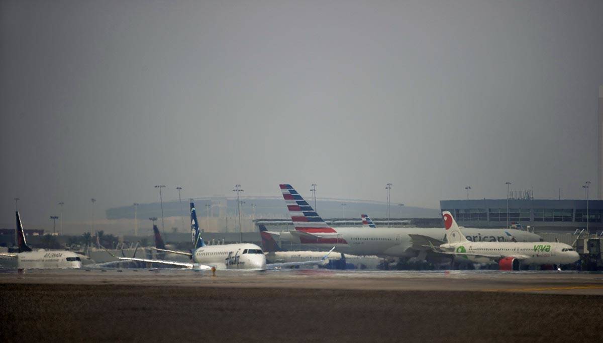 Planes move along the tarmac at McCarran International Airport with wildfire smoke drifting int ...