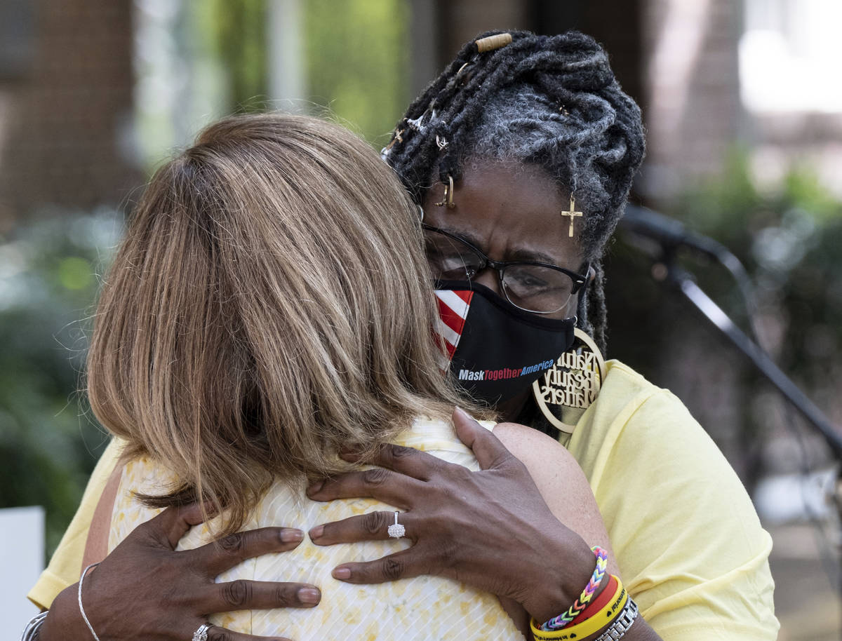 Marjorie Roberts, right, hugs Tanya Washington after speaking about how COVID effected her duri ...