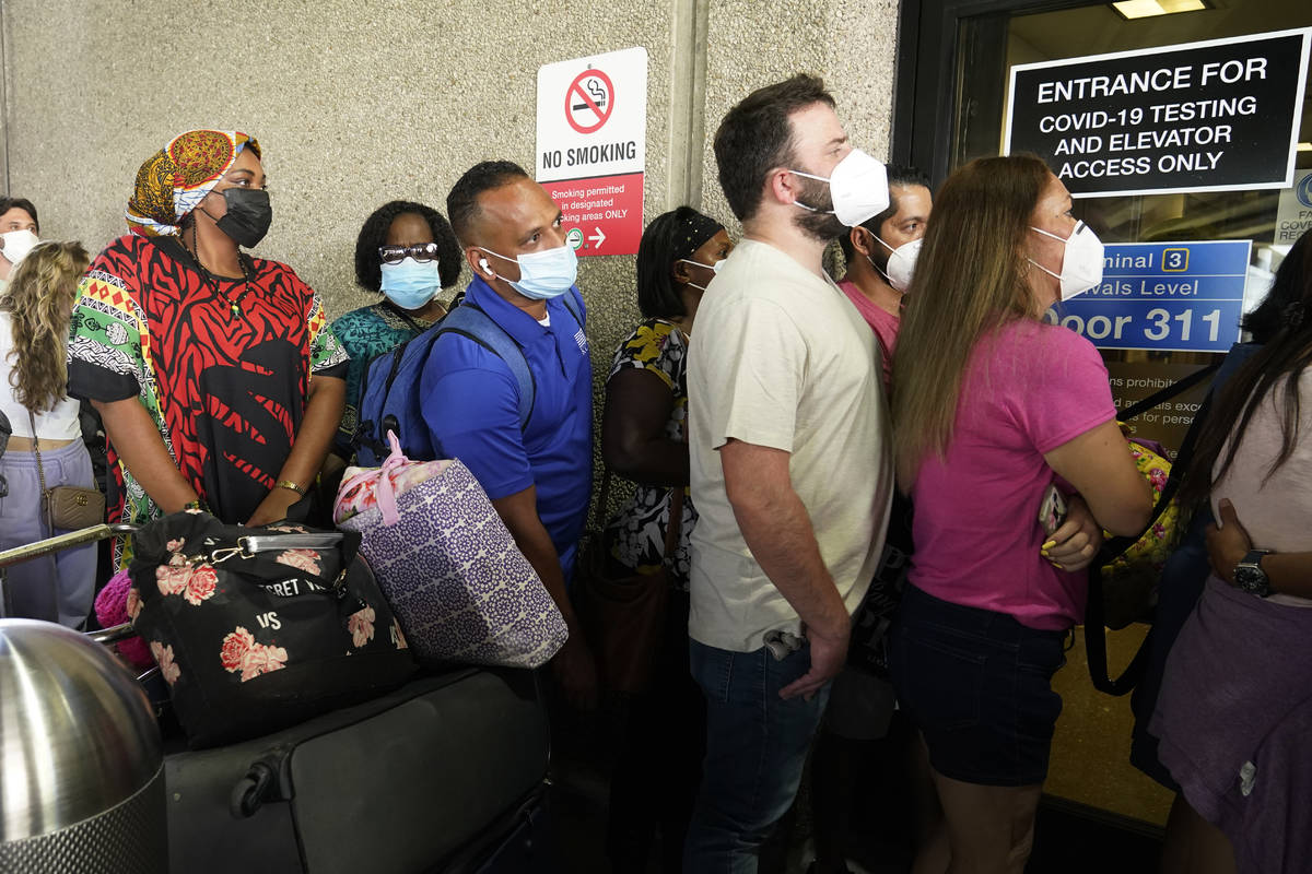 Passengers wait in a long line to get a COVID-19 test to travel overseas at Fort Lauderdale-Hol ...