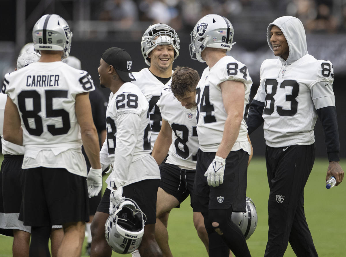 Raider players joke around on the sideline during a special training camp practice for season t ...