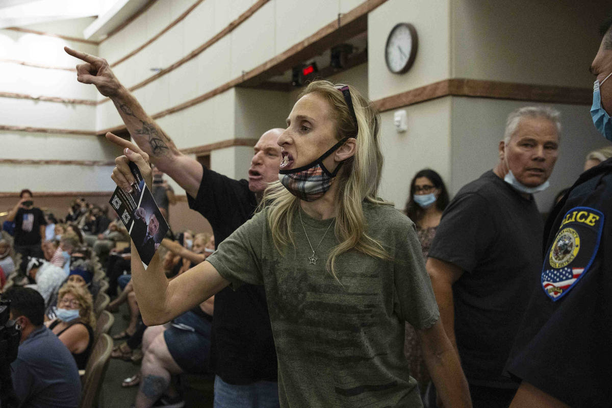 Protesters against a COVID-19 mandate gesture as they were escorted out of the Clark County Sch ...
