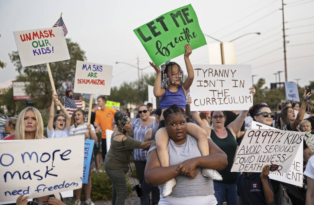 Protesters hold signs opposing the mask mandate for Clark County School District students on We ...