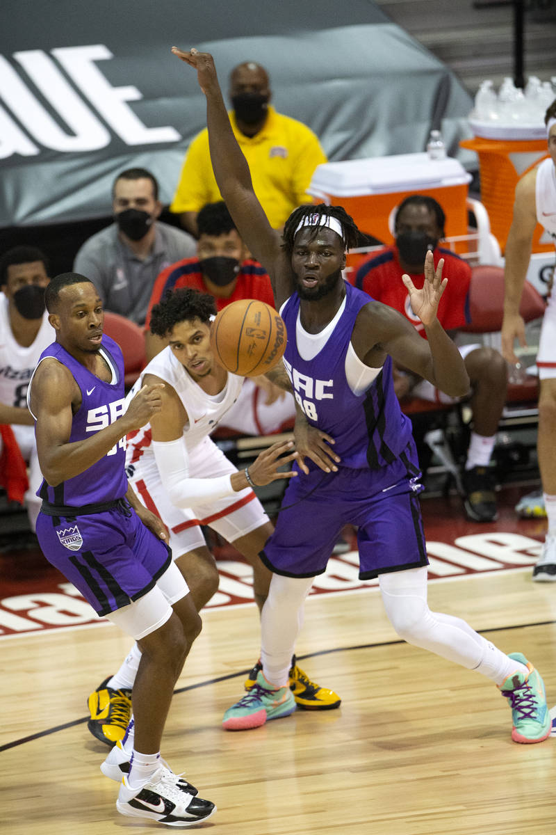 Sacramento Kings guard Matt Coleman, left, and center Neemias Queta, right, eye the ball as Was ...