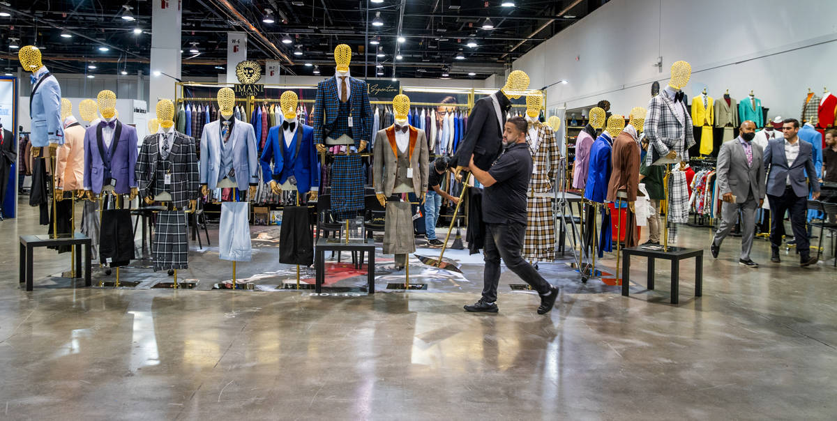 Eli Imani moves around some pieces in his Imani Uomo display during the MAGIC apparel show in t ...