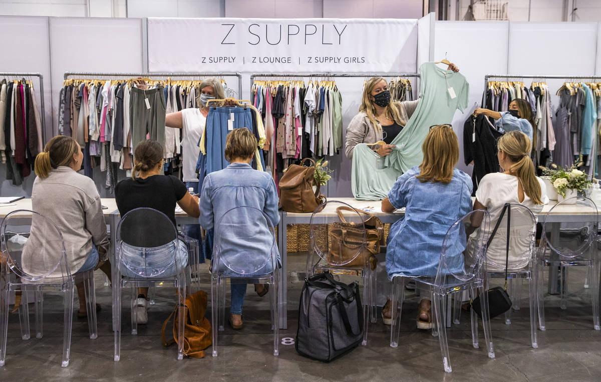 Buyers check outage new pieces for sale by Z Supply at their display during the MAGIC apparel s ...