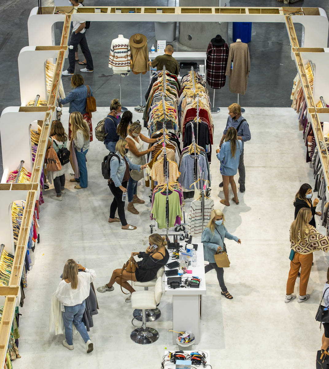 Attendees comb through new items within a display during the MAGIC apparel show in the west hal ...