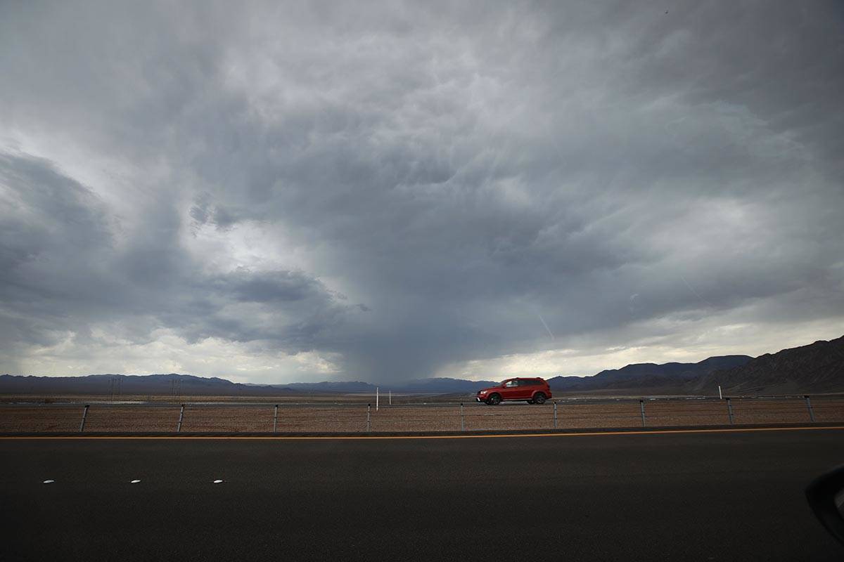 A car drives on U.S. Route 93 around Boulder City, Wednesday, July 21, 2021, when dark clouds d ...