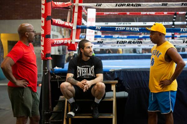 Boxer Nico Ali Walsh, center, speaks with his athletic performance training coach B.B. Hudson, ...