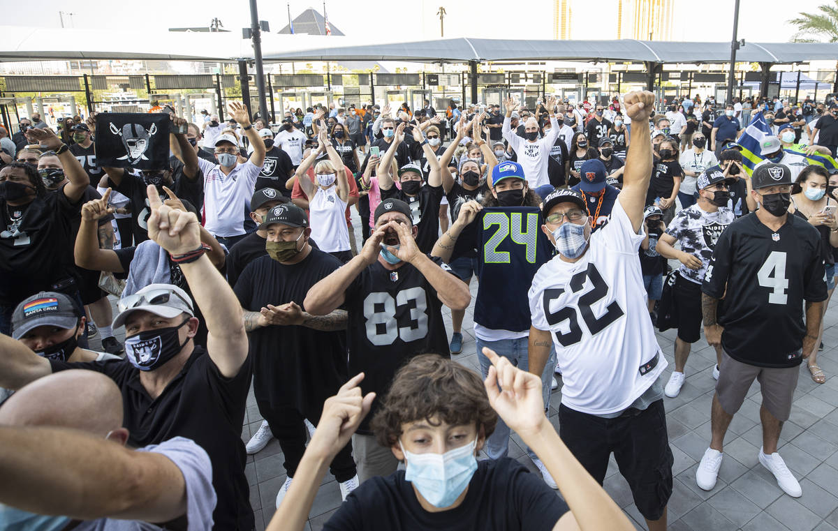 Fans cheer outside Allegiant Stadium before the start of an NFL preseason football game between ...