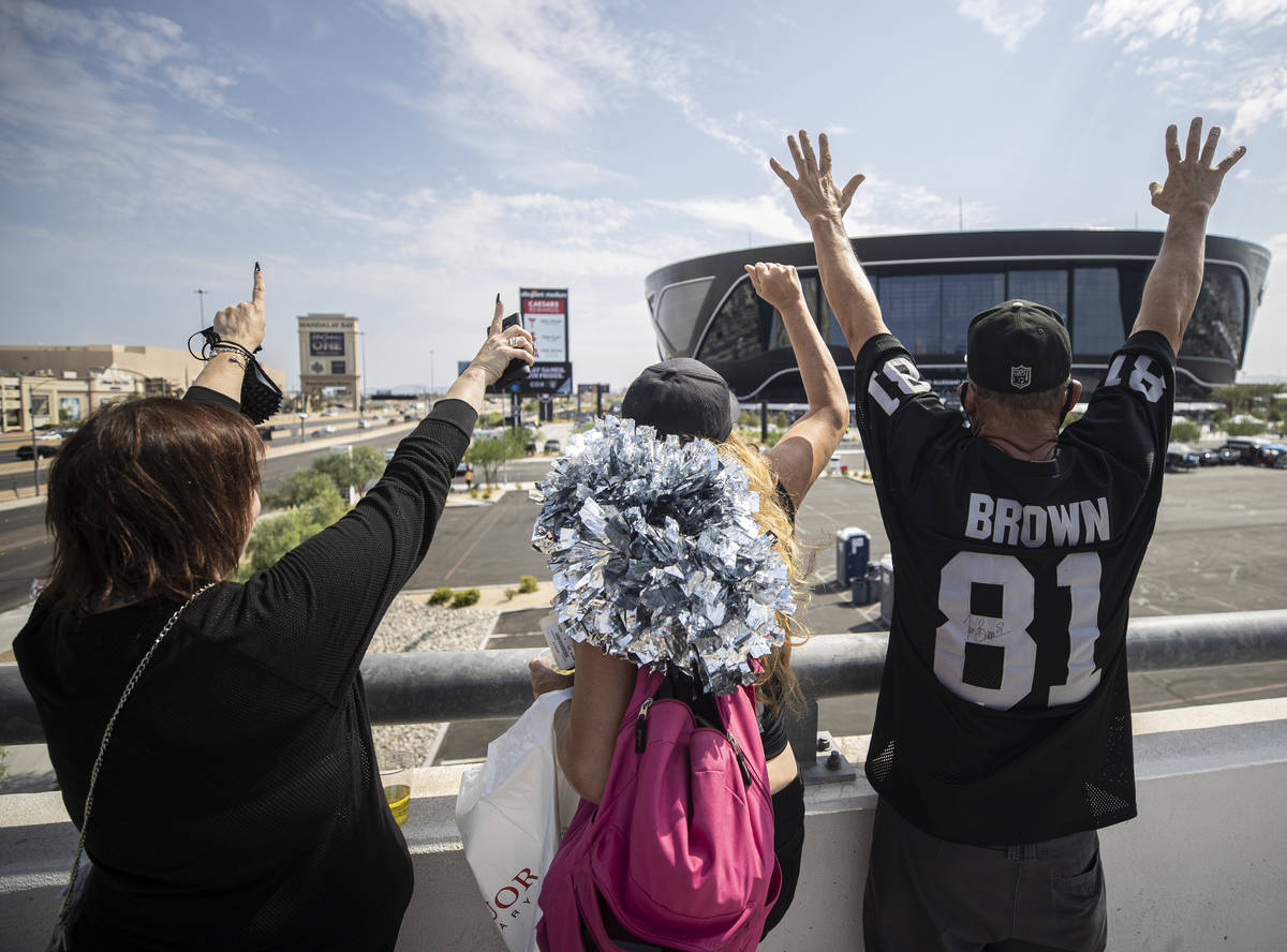 Raiders fans Laurie Rayner, left, Ginger Brown and John Gaynor cheer outside Allegiant Stadium ...