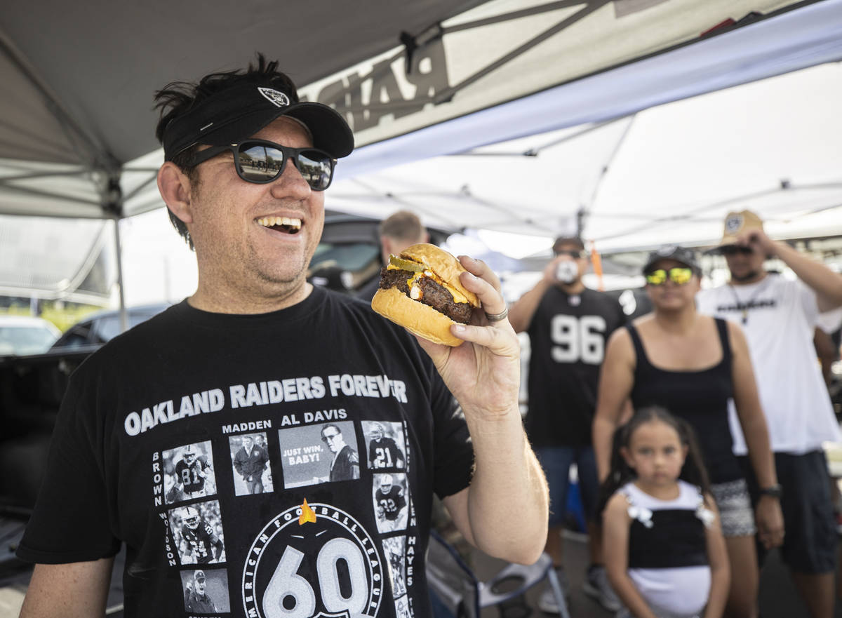 Raiders fan Darrell Padilla grills burgers while tailgating outside Allegiant Stadium before th ...