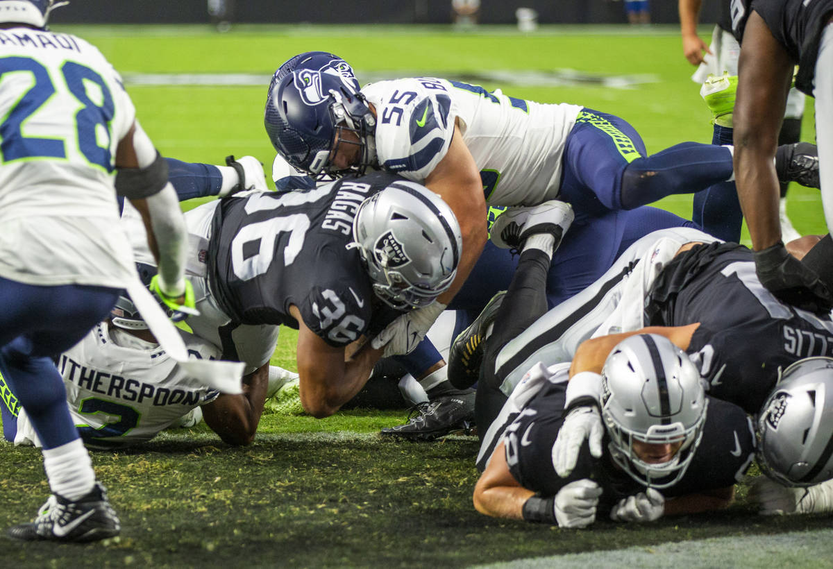 Raiders running back Trey Ragas (36) scores the first touchdown as Seattle Seahawks linebacker ...