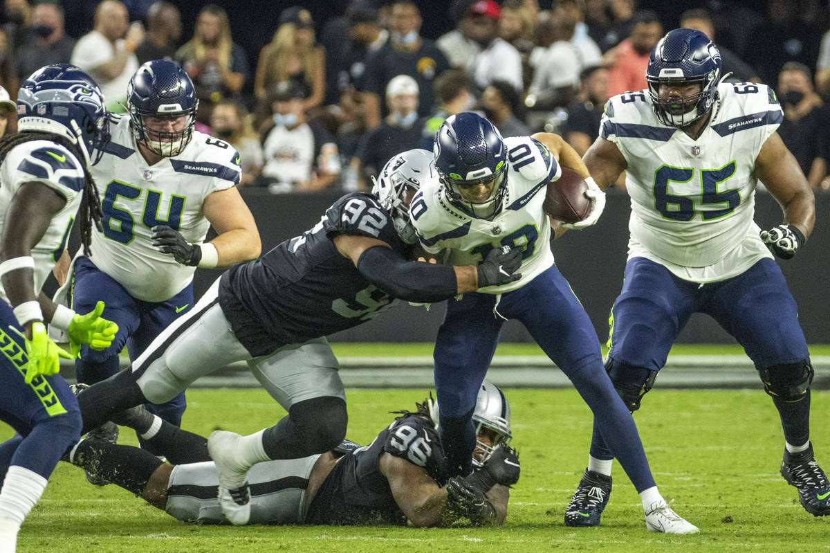 Seattle Seahawks quarterback Alex McGough (10) is tackled by Raiders  defensive end Solomon Thom …