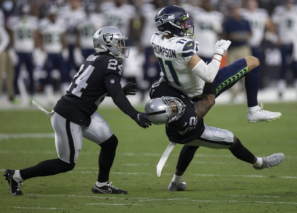 Raiders defensive back Keisean Nixon (22) tackles Seattle Seahawks wide receiver Cody Thompson ...