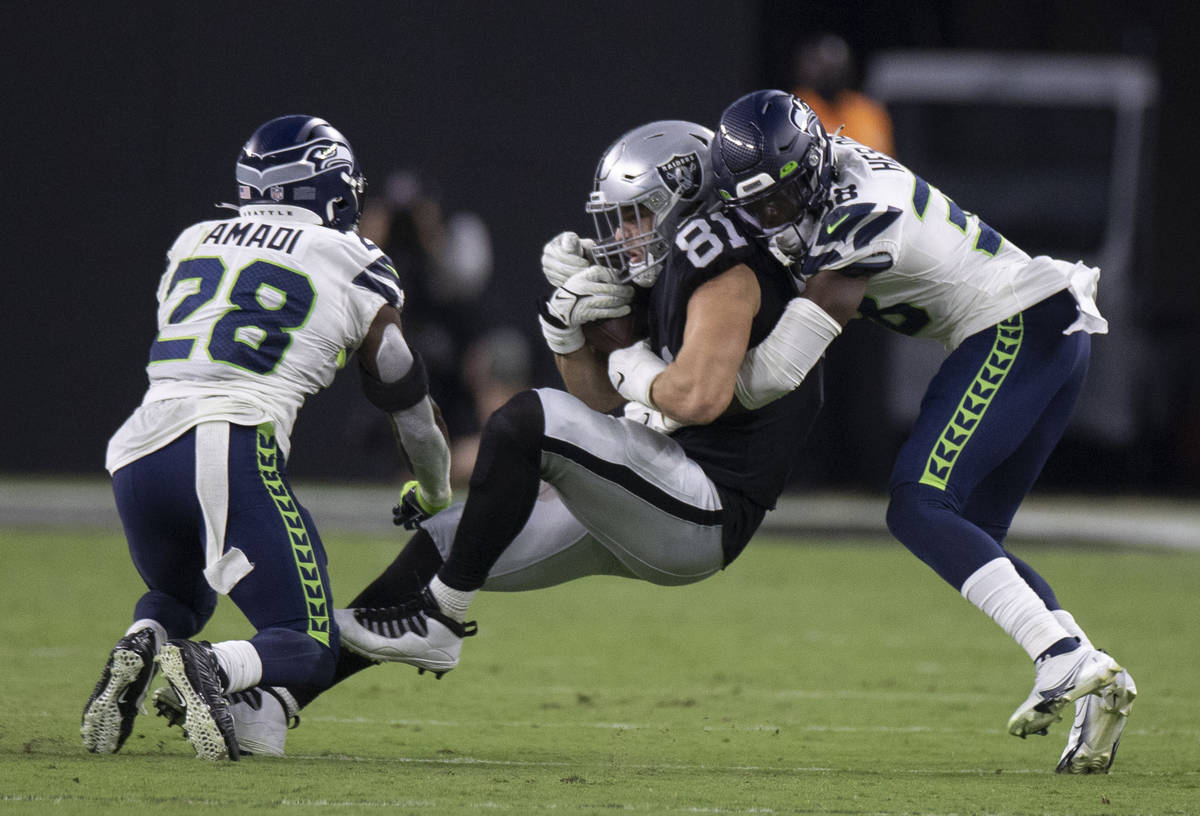 Raiders tight end Alex Ellis (81) is tackled by Seattle Seahawks defensive back Gavin Heslop (3 ...
