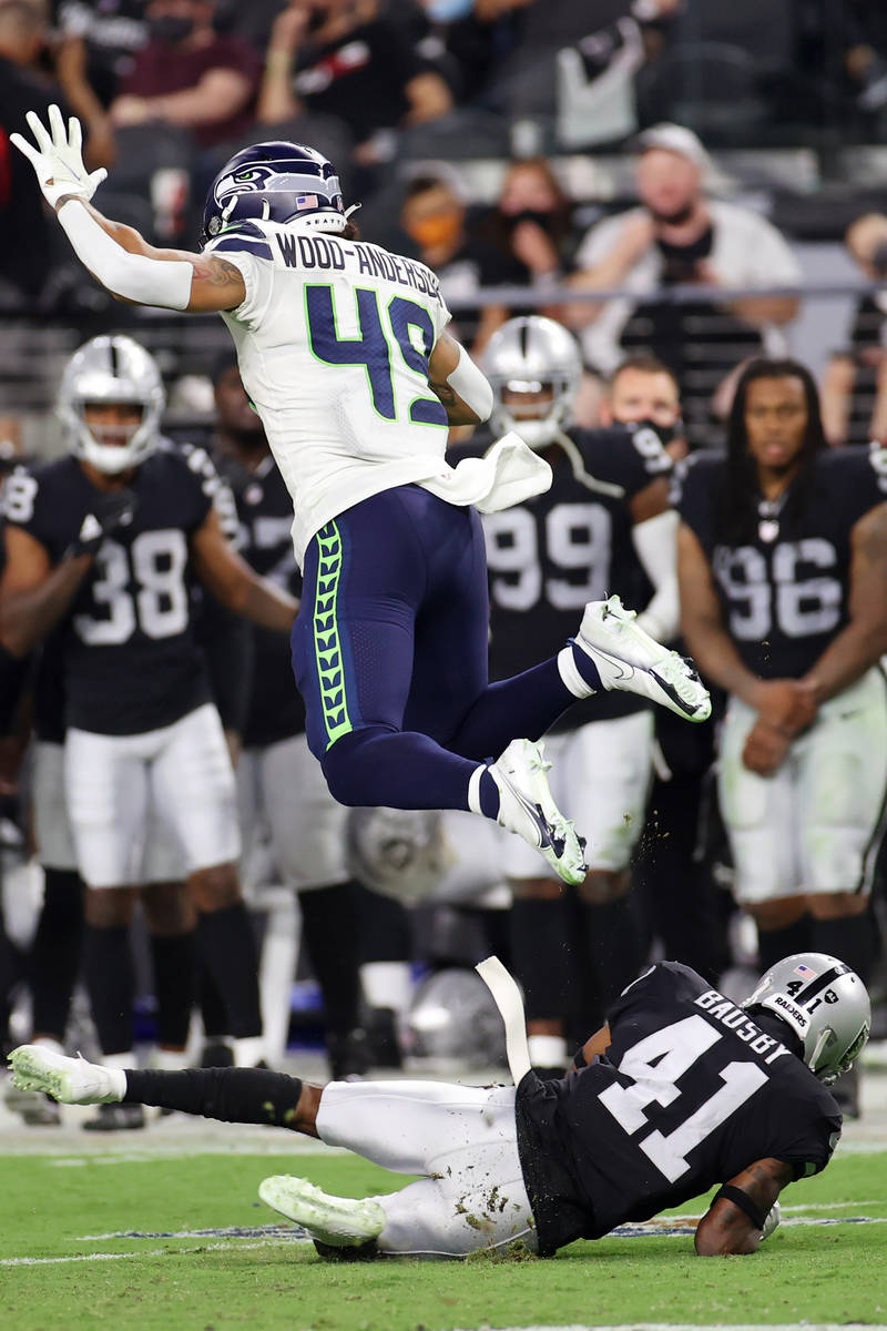 Seattle Seahawks tight end Dom Wood-Anderson leaps over Las Vegas Raiders cornerback DeVante Ba ...