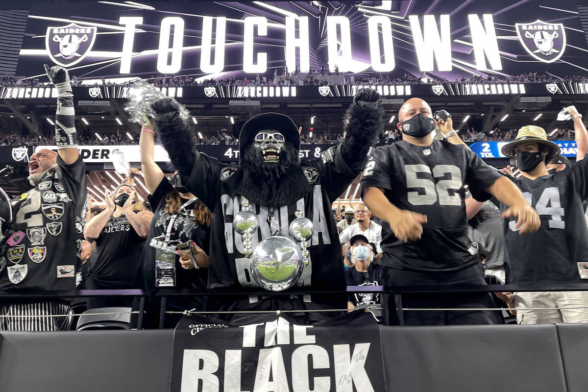 Fans, including Mark Acasio as Gorilla Rilla cheer a touchdown during the Raiders home opening ...