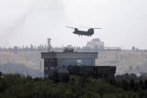 A U.S. Chinook helicopter flies over the U.S. Embassy in Kabul, Afghanistan, Sunday, Aug. 15, 2 ...