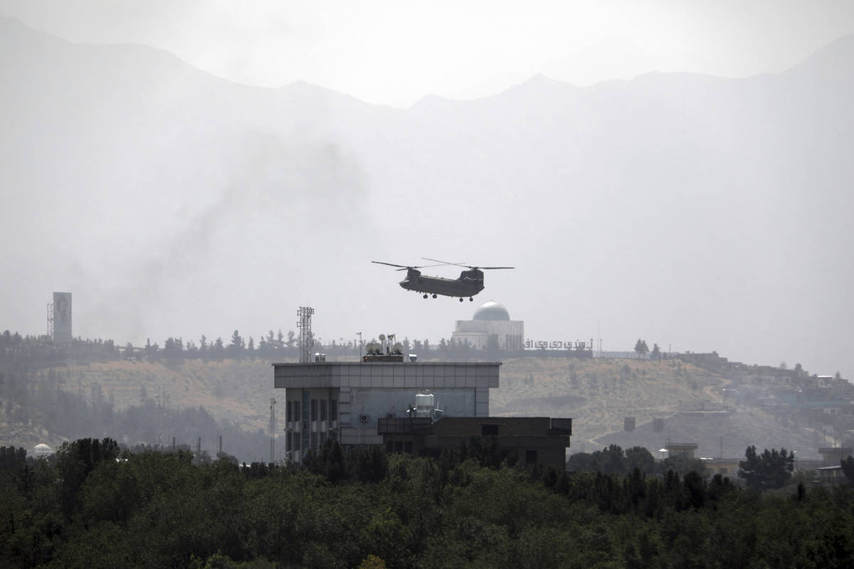 A U.S. Chinook helicopter flies over the U.S. Embassy in Kabul, Afghanistan, Sunday, Aug. 15, 2 ...