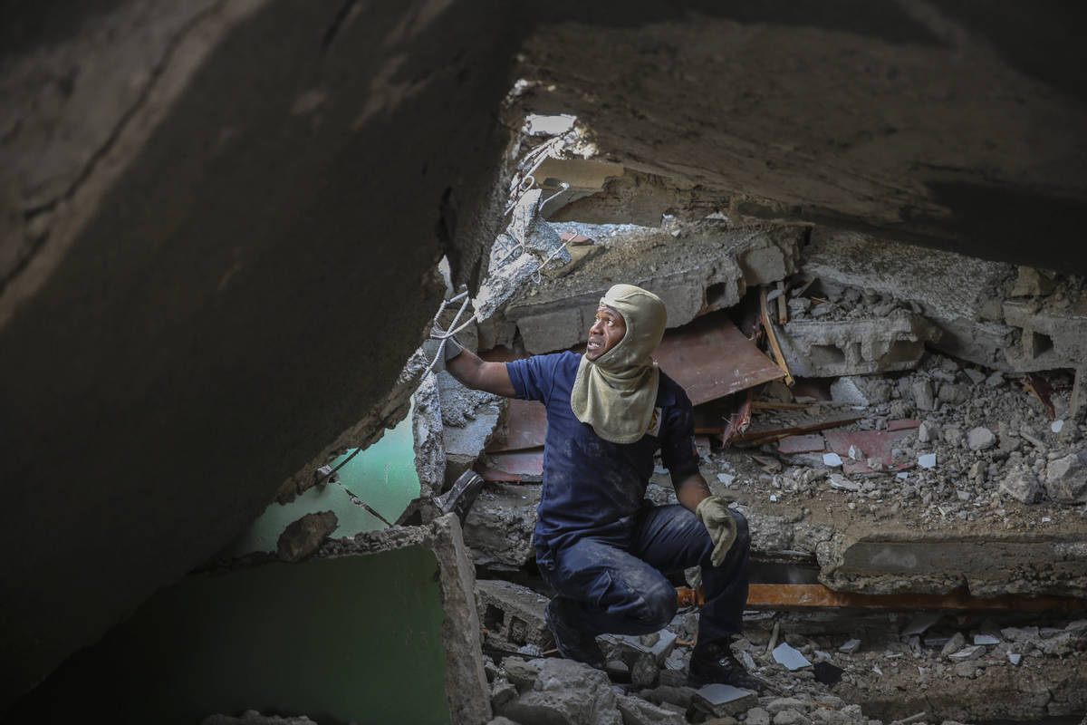A firefighter searches for survivors inside a damaged building, after Saturday´s 7.2 magn ...