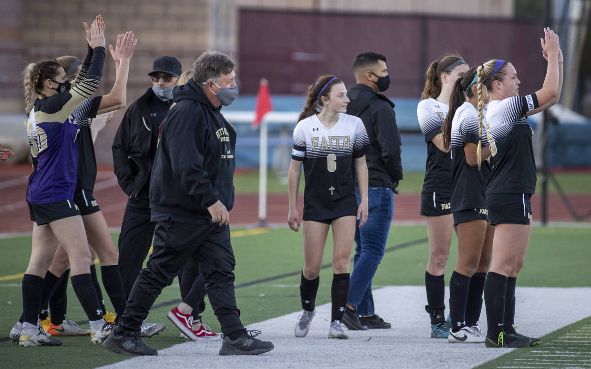 Faith Lutheran head coach Bob Chinn and players applaud the play of Bishop Gorman after winning ...