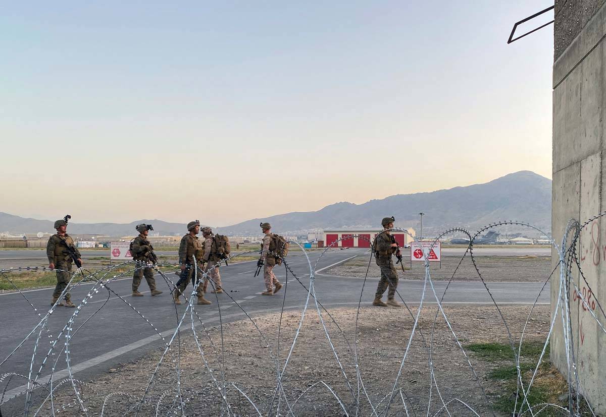 U.S. soldiers stand guard along a perimeter at the international airport in Kabul, Afghanistan, ...