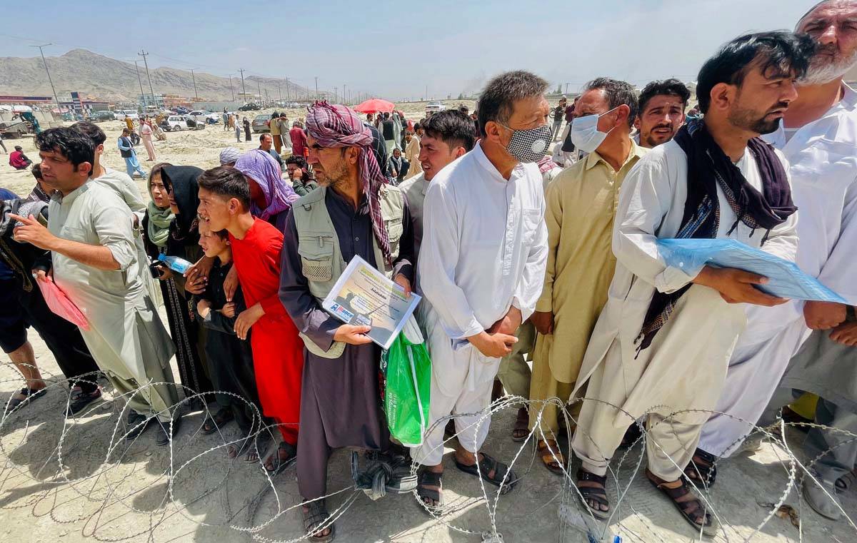 A man holds a certificate acknowledging his work for Americans as hundreds of people gather out ...