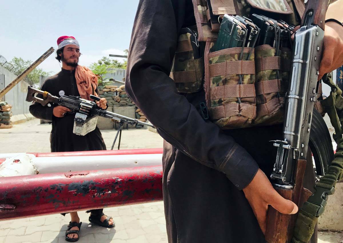 Taliban fighters stand guard at a checkpoint near the US embassy that was previously manned by ...