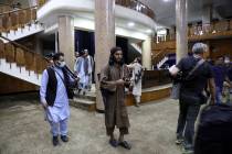 Taliban fighters stand guard before the Taliban spokesman Zabihullah Mujahid arrives for his fi ...