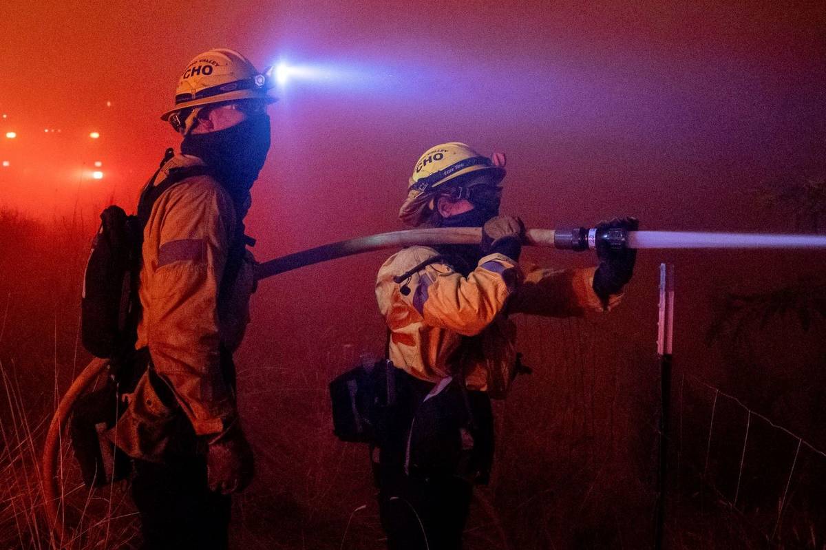Firefighters from a Chino Valley task force battle the Dixie fire as it jumps Highway 395 south ...