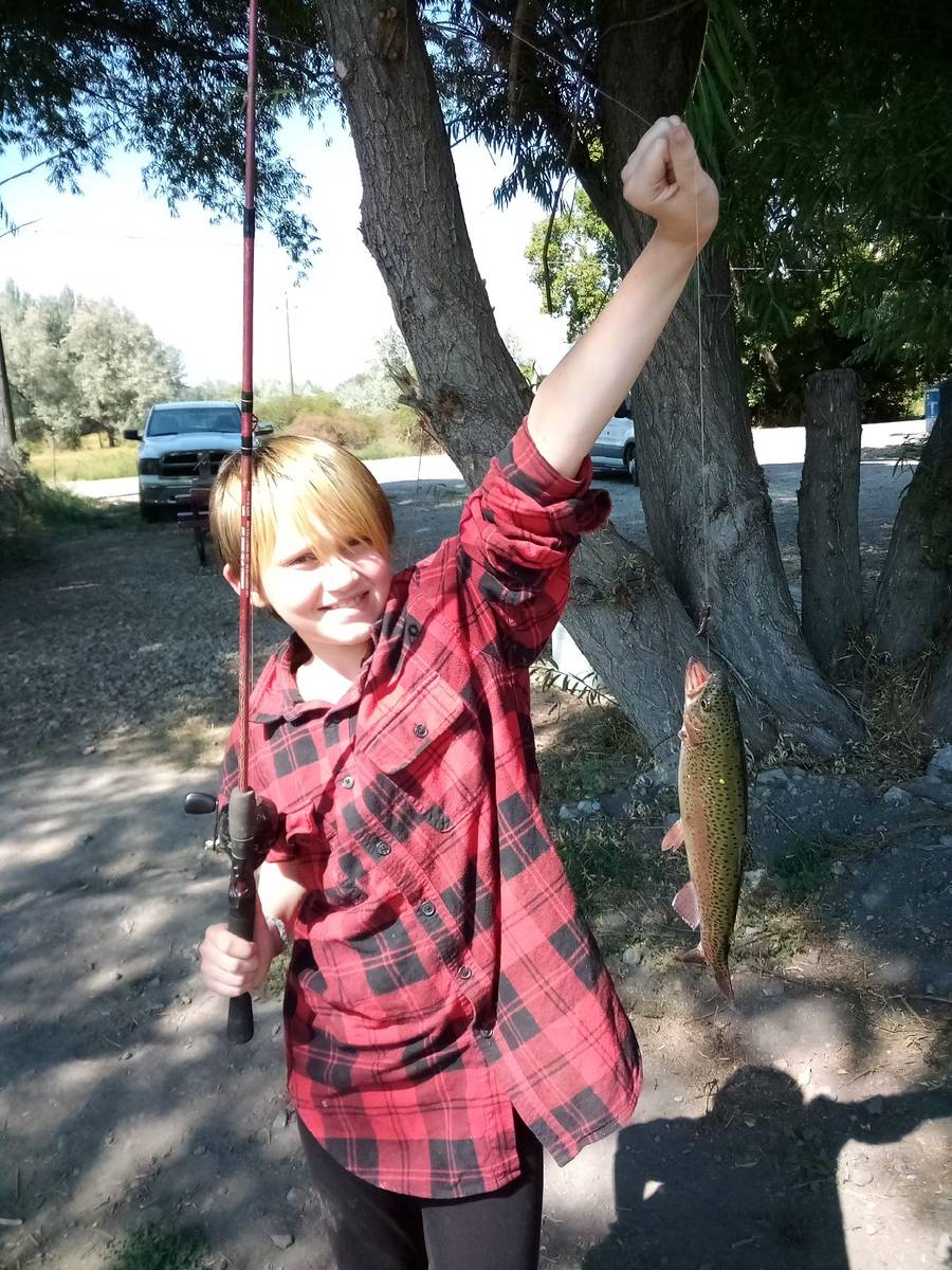 Kesly Koch, 9, shows off a plump rainbow she reeled in while trout catching with her Uncle Jay. ...