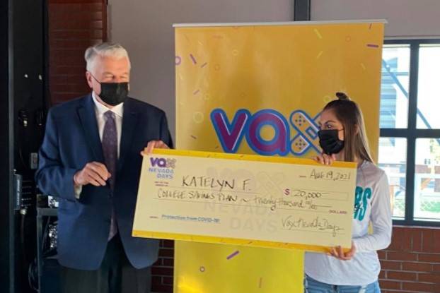 Gov. Steve Sisolak presents a novelty check to Katelyn F. of Reno after she won a $20,000 colle ...