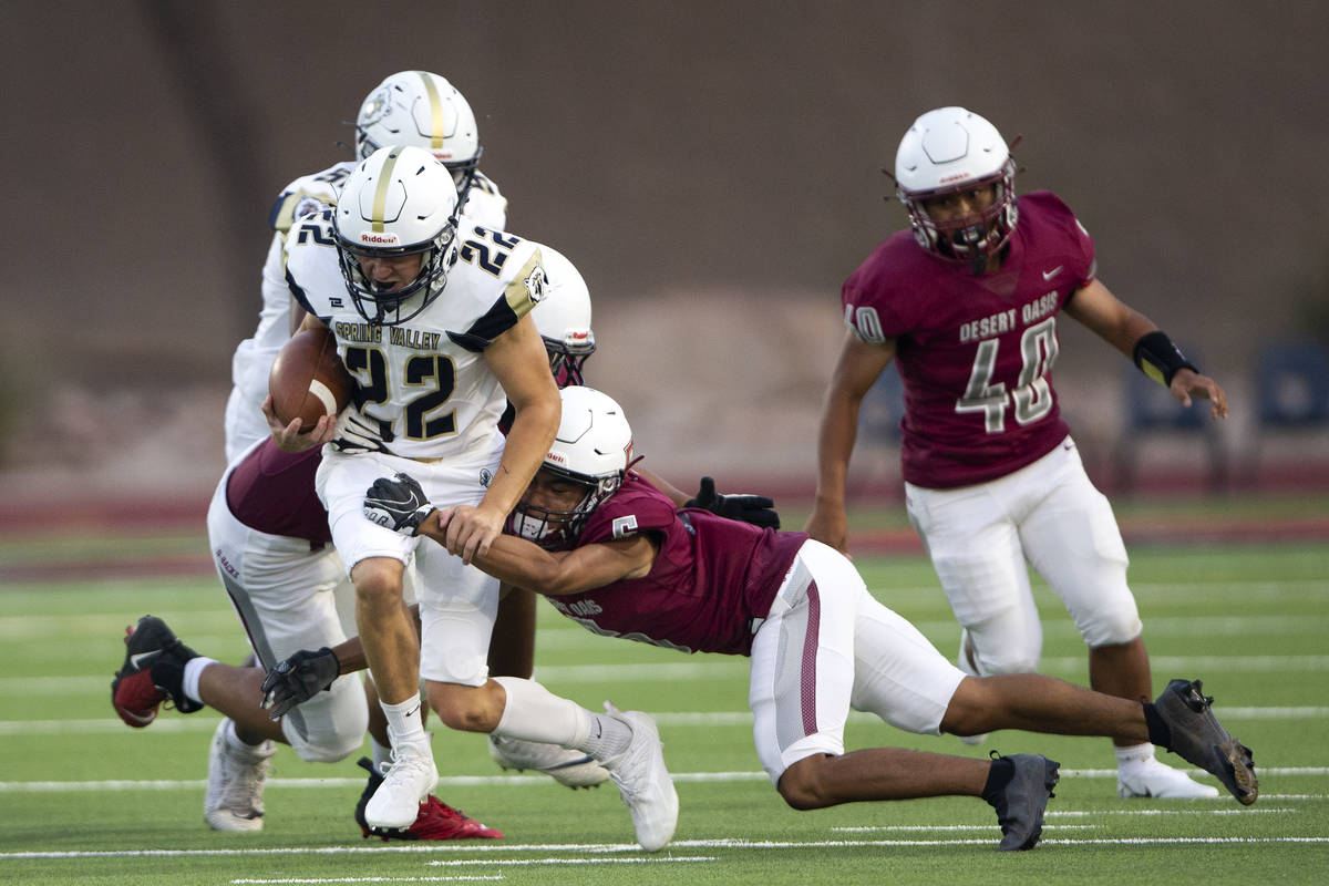 Spring Valley running back Gregory Staron (22) is tackled by Desert Oasis wide receiver Vonnhar ...