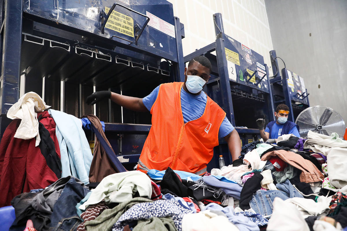 Steverson Green picks up clothes to put in the baler at the warehouse at Goodwill Clearance Cen ...