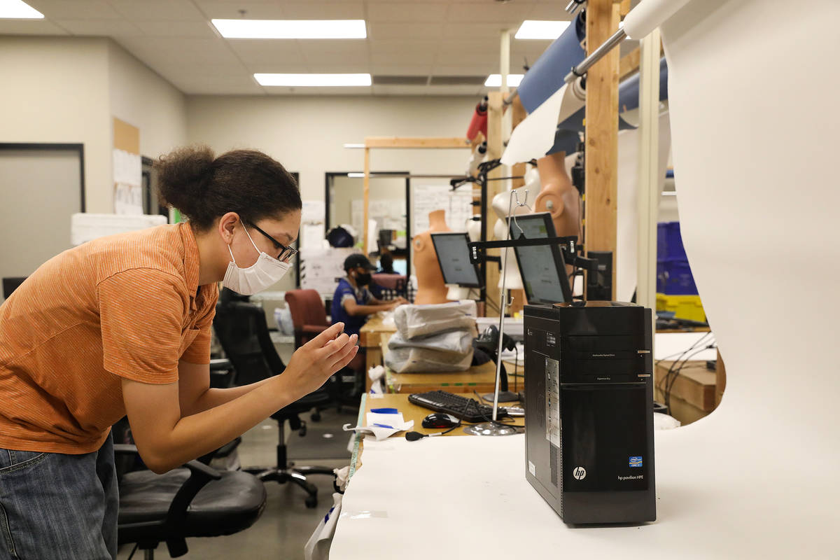 Elise Noblin, refurbishing assistant, takes photos of a donated computer modem to resell online ...
