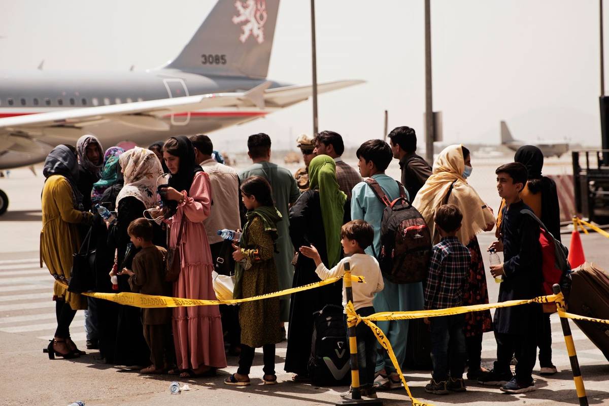 Civilians prepare to board a plane during an evacuation at Hamid Karzai International Airport, ...