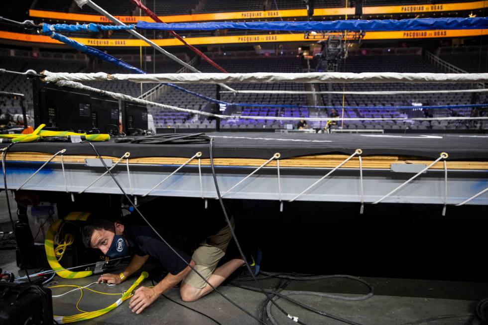 Lucas Males, broadcast engineer at Game Creek Video, works under the boxing ring for the upcomi ...