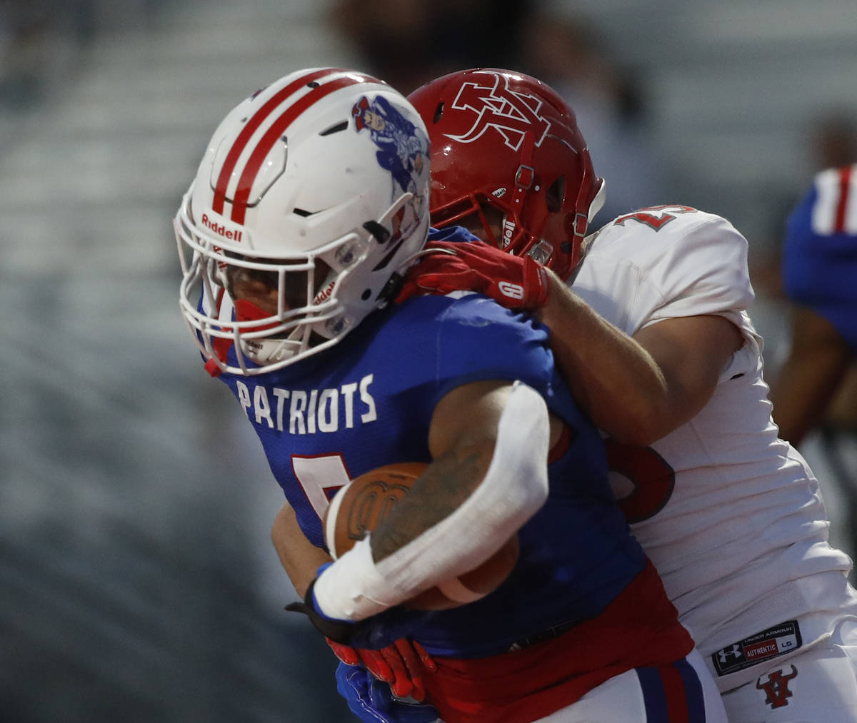 Liberty High School's Anthony Jones (5) is tackled by Arbor View High School's Tanner Aitken (2 ...