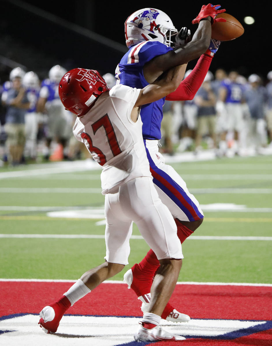 Liberty High School's Germie Bernard (2), catches a pass as Arbor View High School's Jason Serm ...