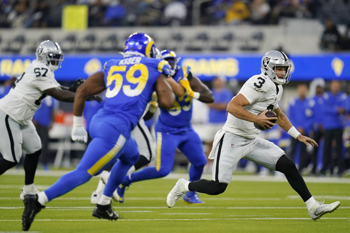 Las Vegas Raiders quarterback Nathan Peterman, right, carries against the Los Angeles Rams duri ...