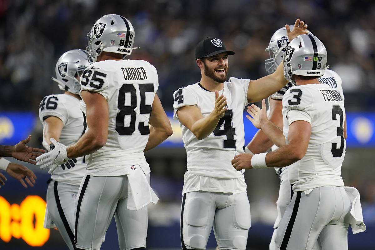 Las Vegas Raiders quarterback Derek Carr (4) celebrates with quarterback Nathan Peterman (3) af ...