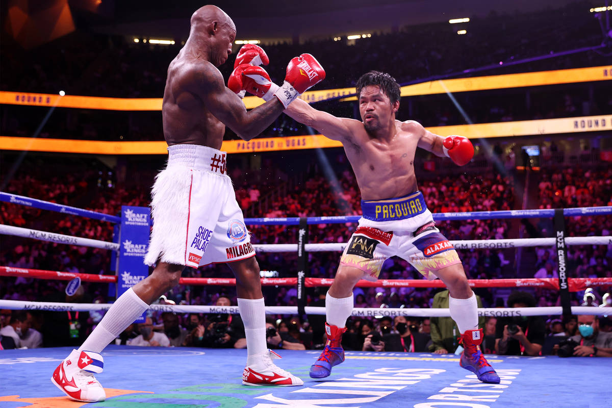 Yordenis Ugas, left, battles Manny Pacquiao in the sixth round of the WBA World Welterweight Ti ...