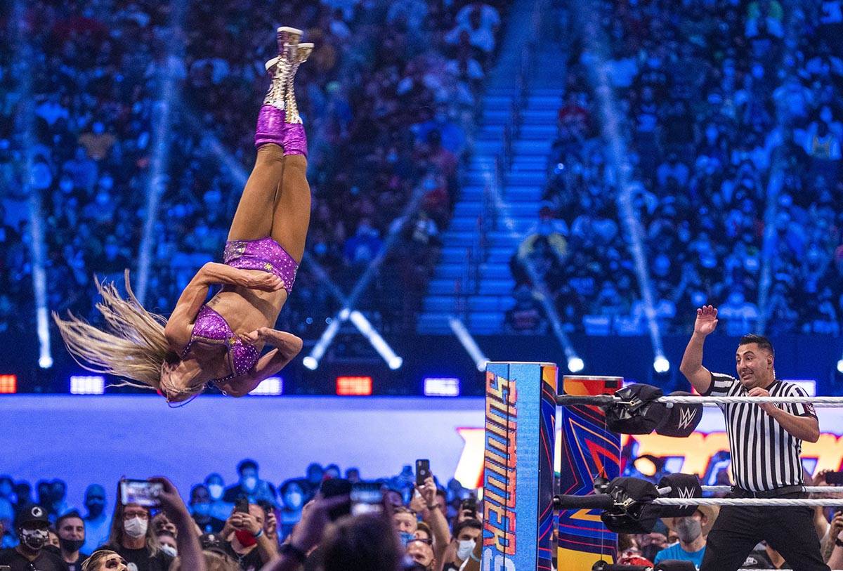 Charlotte Flair flies off the top ropes onto Nikki A.S.H. and Rhea Ripley below in the Raw Wome ...