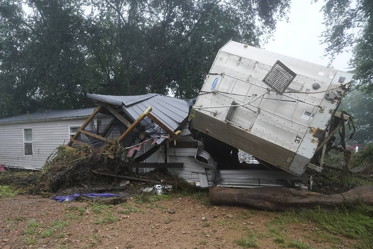 A mobile home and a truck trailer sit near a creek Sunday, Aug. 22, 2021, after they were washe ...