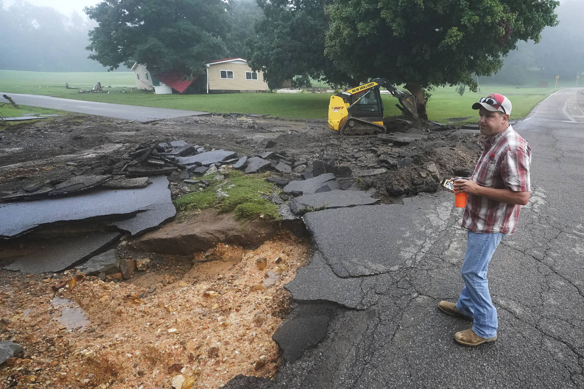 CORRECTS ID TO MICHAEL PATE NOT WAYNE SPEARS. Michael Pate watches as a road is repaired Sunday ...